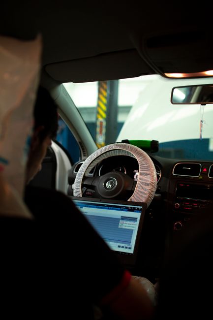 Technicien réalisant un diagnostic électronique sur ordinateur depuis le poste de conduite